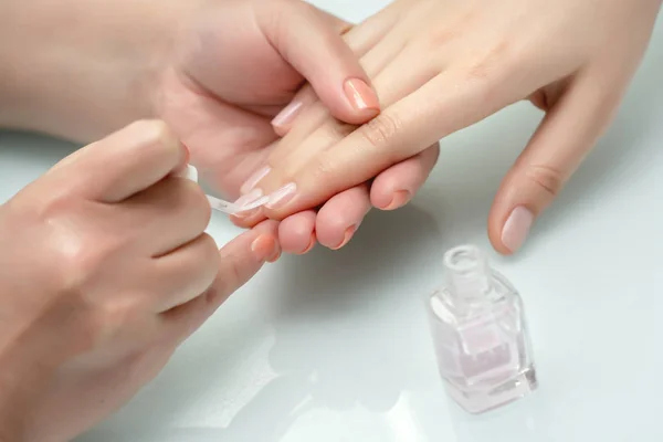 Kvinnliga händer i en nagelsalong som får manikyr. — Stockfoto