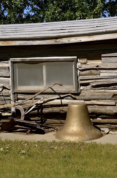 Antigua campana de cobre y herramientas delante de la cabina de madera — Foto de Stock