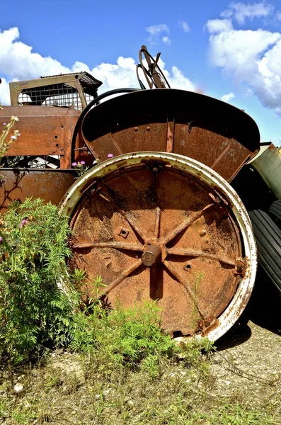 У старого ржавого трактора пропало колесо — стоковое фото
