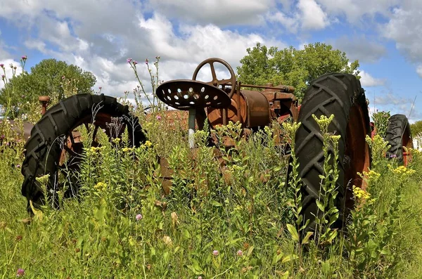Gamla rostiga traktorn i en en tistel patch — Stockfoto