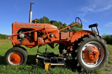 Geri yüklenen Allis Chalmers traktör göbek biçme makinesi ile