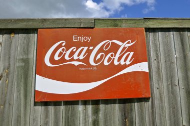 Ahşap bir çit üzerinde eski Coca Cola işareti