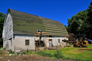 Preparing a barn for a new metal roof clipart