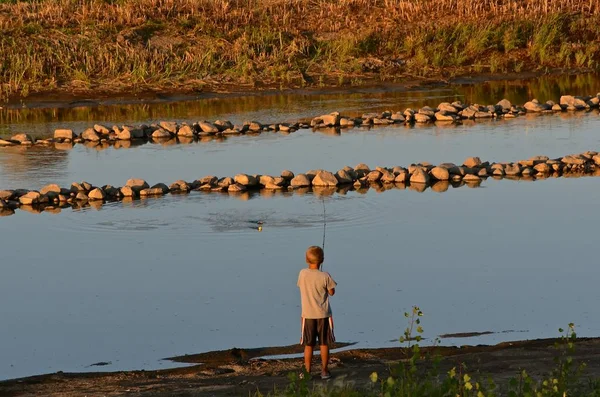 Menino pesca em um canal — Fotografia de Stock