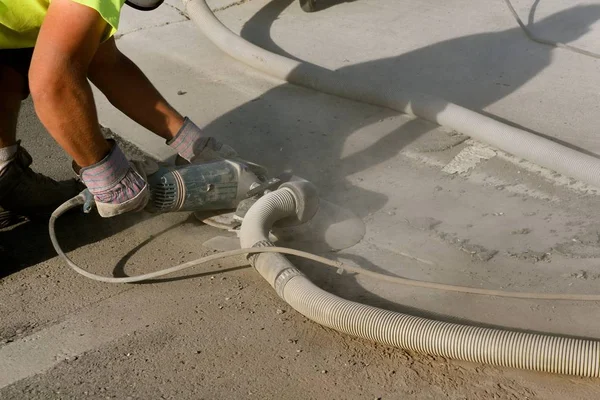 Unidentified worker grinding  concrete edge pavement between  curb and street — Stock Photo, Image