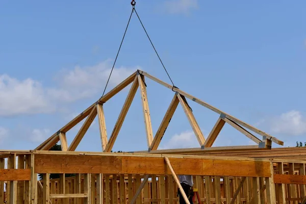 Μεταφορά trusses(rafters) στην κορυφή του ένα κτίριο υπό κατασκευή — Φωτογραφία Αρχείου