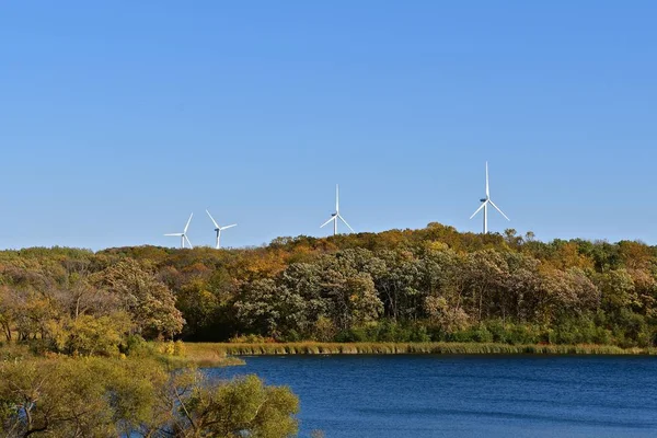 Wind turbines behind autumn colored woods — Stock Photo, Image