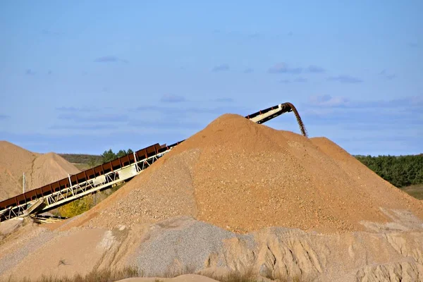 Montón de arena enorme siendo alimentado por una cinta transportadora — Foto de Stock