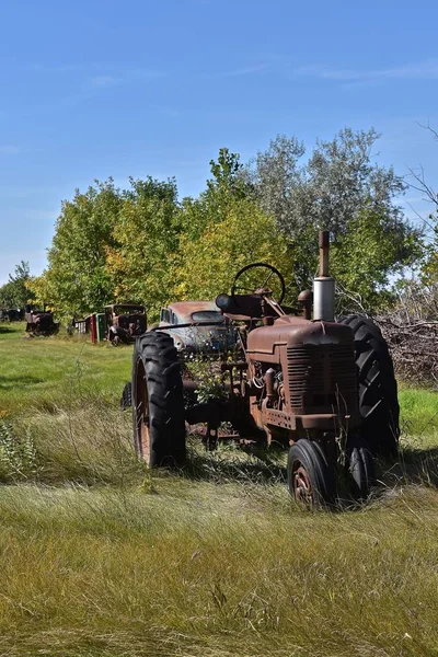 Oude roestige trekker geparkeerd in in een weiland — Stockfoto