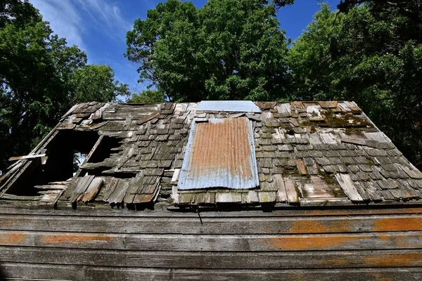 Sac ile yamalı bir eski dökmek çürüyen çatı — Stok fotoğraf