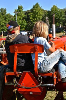 Rollag, Minnesota, 2 Eylül 2017: Tanımlanamayan kardeş nerede 1000 katılmak yıllık Wcstr Rollag çiftlik gösterisinde her İşçi Bayramı hafta sonu düzenlenen törende bekleyen bir traktör koltuğuna rest.