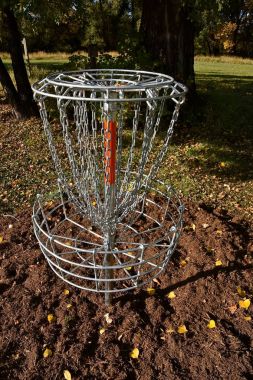 Bir kümesi ağaçlar yapraklarını sonbahar sezonunda bağsız'in bir parkta bir frizbi sepet.