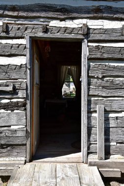 Odanın diğer tarafında pencereli açık ahşap kabin kapısı