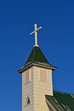 Yeni bir metal yeşil çatı ile beyaz bir kilisenin Steeple üzerinde kar ve buz izleri görünür