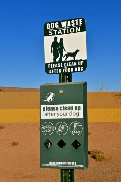 A dog waste station with signs, instructions, and materials.