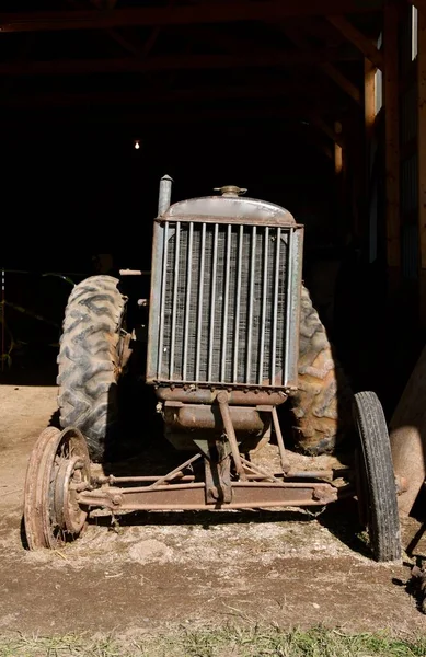 漏掉前胎的旧拖拉机停在小木屋门口 — 图库照片