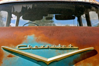 LAKE PARK, MINNESOTA, September 5, 2019: The old rusty car with the logo is a 1957 Chevrolet , colloquially referred to as Chevy and formally the Chevrolet Division of General Motors Company, is an American automobile division of the manufacturer clipart