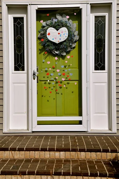 A house door is decorated with hearts as encouragement is provided during covid-19 pandemic.