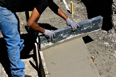 Bir beton işçisi, bodrum katından çamur iter..