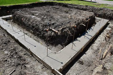 Çapa çubuklarının gölgelerini attığı bir inşaat sahasında beton elde etmek için formlar oluşturulmuştur..