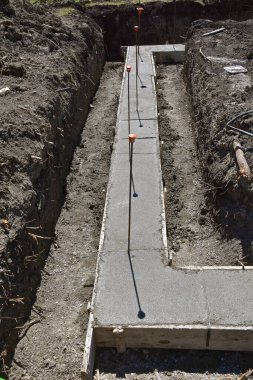 Çapa çubuklarının gölgelerini attığı bir inşaat sahasında beton elde etmek için formlar oluşturulmuştur..