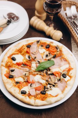 Pizza domates, jambon ve zeytin ile