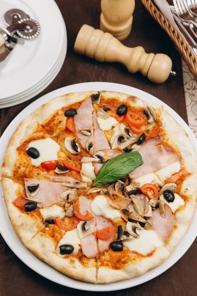 Pizza domates, jambon ve zeytin ile