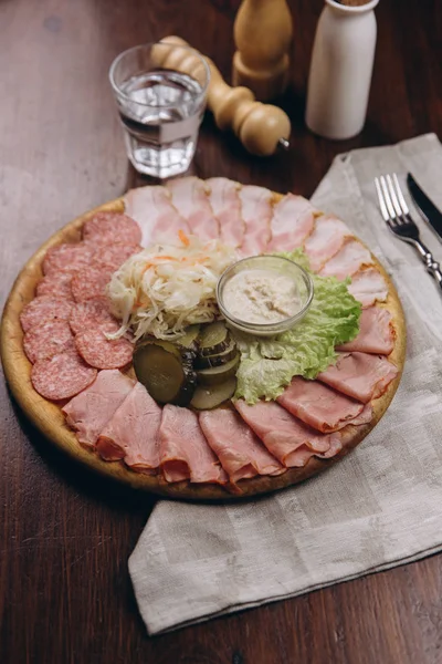 Salami, ham and bacon on wooden board — Stock Photo, Image
