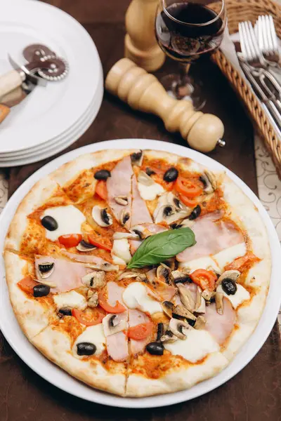 Pizza domates, jambon ve zeytin ile