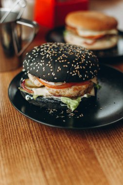 Siyah burger ve siyah plakalar üzerinde düzenli burger 