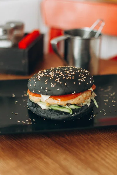 Black Burger mit Fischschnitzel und Tomaten — Stockfoto