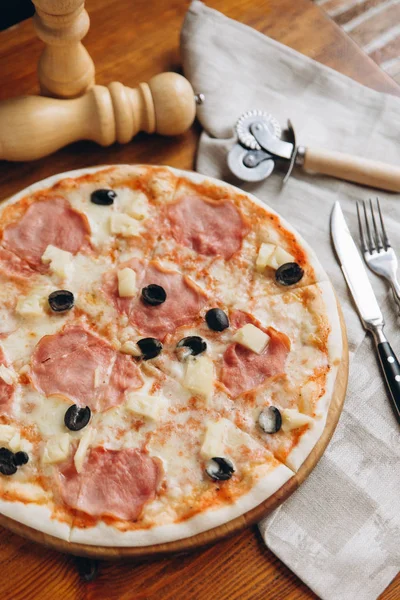 Cheese pizza with ham and olives