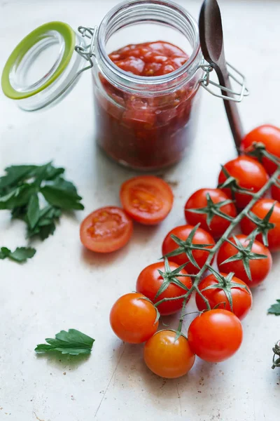 Tomates vermelhos e jarra de molho de tomate caseiro — Fotografia de Stock