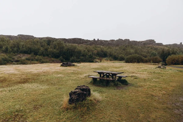 Mesa de madeira e bancos no prado — Fotografia de Stock