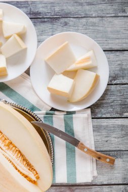 Yukarıdan kesilerek kavun bıçak ve peçete ile beyaz plakaları