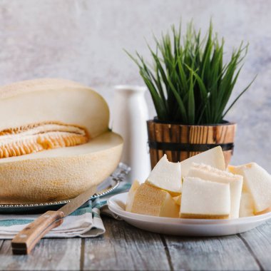 Natürmort bıçak, çizgili peçete, beyaz şişe ve arka plan üzerinde vason kesilerek kavun ile