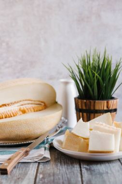 Natürmort kesilerek kavun ile beyaz bıçak, peçete ve arka plan üzerinde vason tabakta