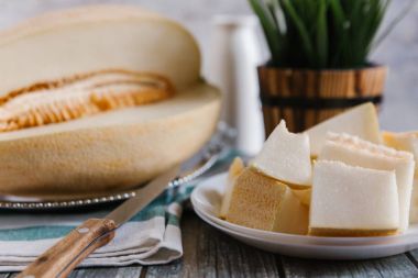 Natürmort kesilerek kavun ile beyaz bıçak, peçete ve arka plan üzerinde vason tabakta