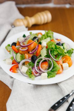 Beyaz plaka üzerinde renkli Yunan salatası Görünümü Kapat