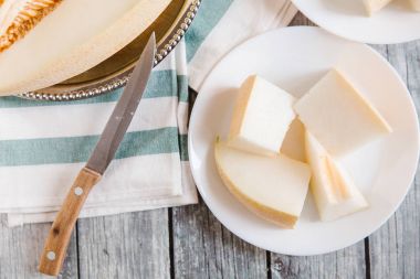 Yukarıdan kesilerek kavun bıçak ve peçete ile beyaz plakaları