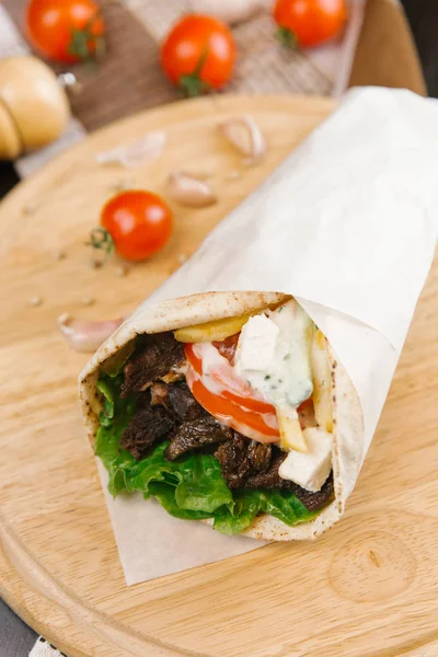 Piatto Legno Con Shawarma Grigliato Croccante Avvolto Carta Pergamena Fondo — Foto Stock