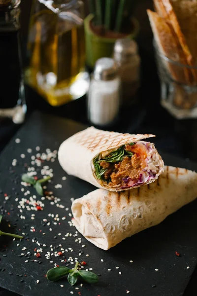 shaverma iki adet germinated ayçiçeği tohumu ve sezame üzerinde arka plan bulanık ile tamamlanmaktadır siyah plaka servis