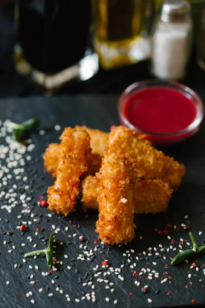 spicies ve sezame ve arka plan bulanık dekore edilmiş siyah plaka üzerinde frambuaz sos ile tofu Nuggets