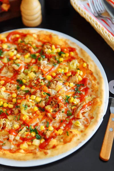 close view of pizza with corn seeds and tomato sauce on black table