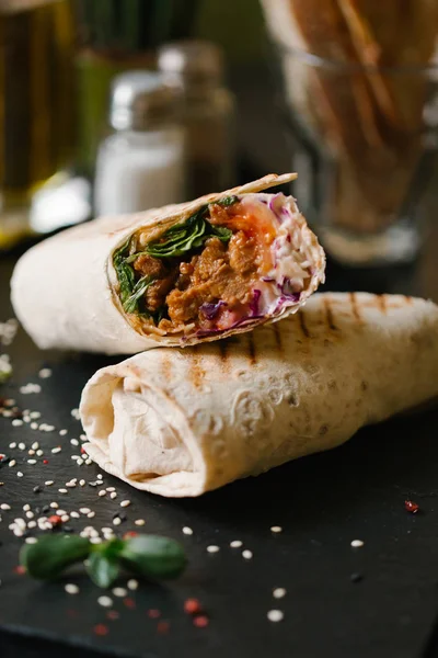 shaverma iki adet germinated ayçiçeği tohumu ve sezame üzerinde arka plan bulanık ile tamamlanmaktadır siyah plaka servis