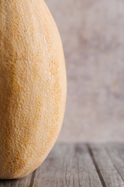 Eski püskü ahşap masa taze kavun ile minimalist kompozisyon