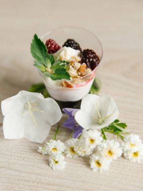 Yunan yoğurt böğürtlen reçeli ve fındık, nane ve böğürtlen ahşap yüzeyi çiçekler ile üst  