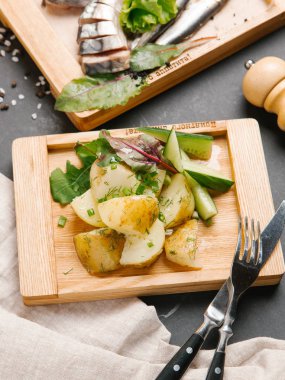 arka plan üzerine dilimlenmiş scomber ile ahşap tahta üzerinde servis sebze ile kavrulmuş patates görünümünü yakın 