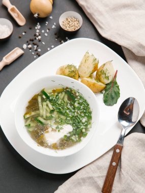 haşlanmış patates ve beyaz tabakta dereotu turşu çorbası