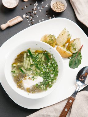 haşlanmış patates ve beyaz tabakta dereotu turşu çorbası